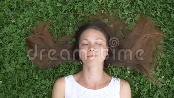 无忧无虑的女人躺在草地上做梦视频的预览图
