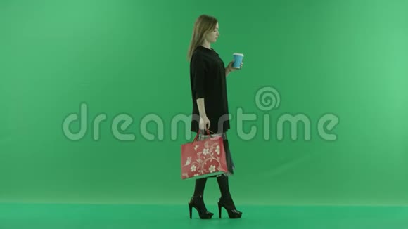 带包的年轻女士购物后喝茶颜色关键绿色背景视频的预览图