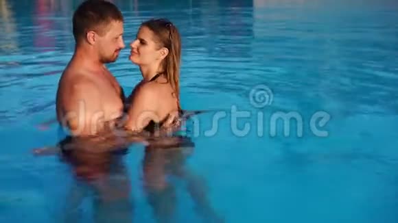 年轻的情侣拥抱在泳池里视频的预览图