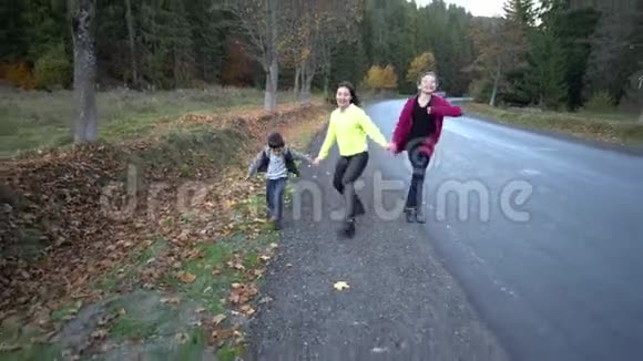 年轻美丽的母亲带着她的孩子在秋天的森林里他们在路上跑步很有趣他们很开心他们视频的预览图
