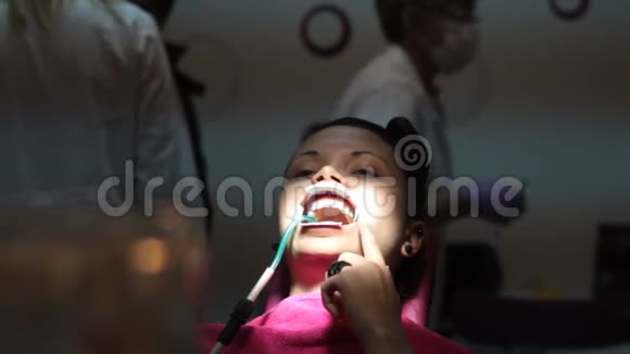 张开嘴的女病人在等待牙医时用手指在脸上抓挠视频的预览图