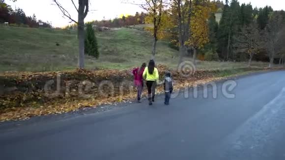 年轻美丽的母亲带着她的孩子在秋天的森林里他们在路上跑步很有趣他们很开心他们视频的预览图