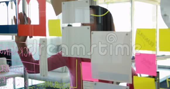 女人在玻璃4k上粘粘纸条视频的预览图