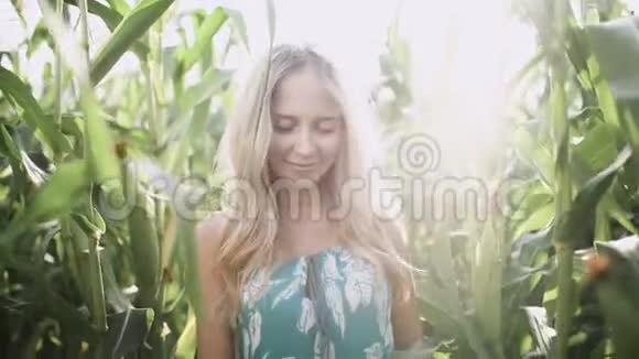 美丽的女孩戴着帽子微笑着在玉米地里慢跑视频的预览图