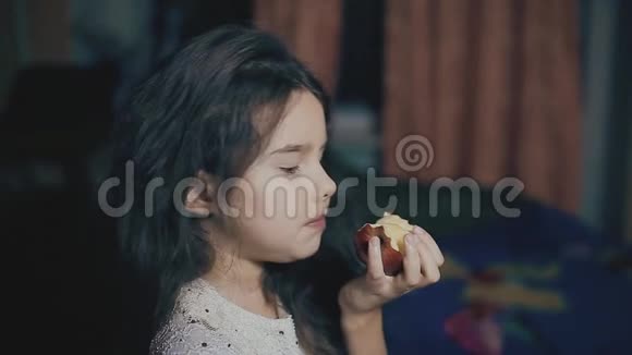 小女孩晚上在房间的室内吃一个苹果健康食品小生活方式女孩和水果苹果视频的预览图
