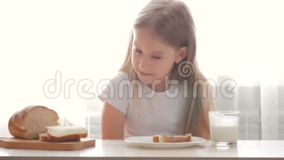 孩子喝牛奶吃三明治一个拿着三明治的女孩正在品尝视频的预览图