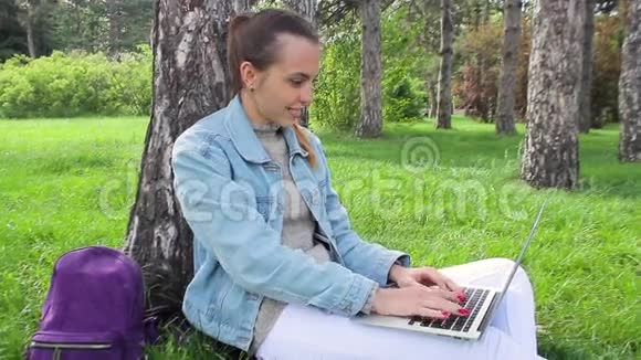 坐在办公楼外面工作的年轻女孩视频的预览图