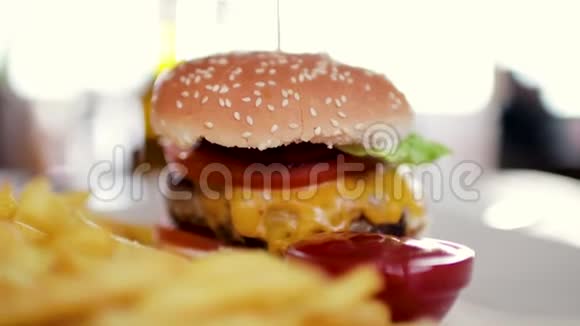 美味的汉堡包一大块排骨和一罐薯条和番茄酱视频的预览图