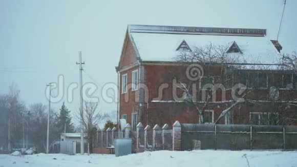 在阴天的冬天下雪的天气砖两层楼的房子视频的预览图
