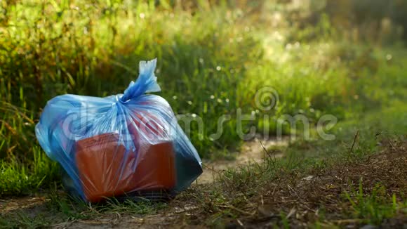 一包塑料垃圾在森林道路上污染自然垃圾和自然垃圾视频的预览图