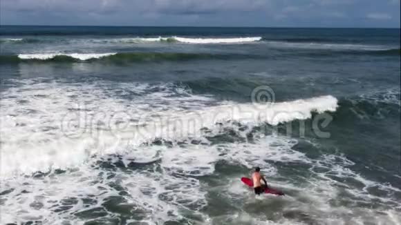 冲浪者带着冲浪板来到大海视频的预览图