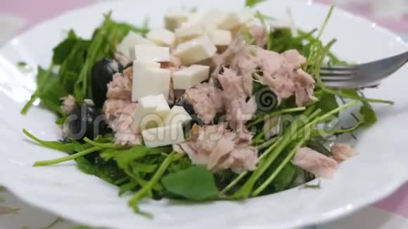 沙拉的绿色奶酪橄榄和鱼特写在盘子里健康食品视频的预览图