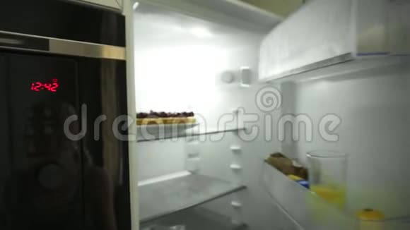 女人的近景她的手走到冰箱前打开门拿出盘子里装饰着的蛋糕视频的预览图