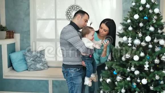 微笑的家庭在客厅装饰圣诞树视频的预览图