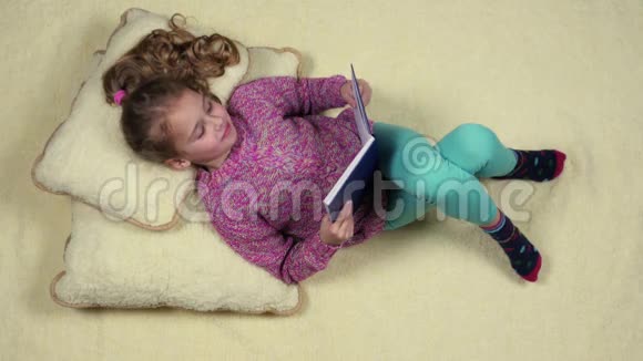 美丽的孩子的顶部景观书躺在枕头上视频的预览图