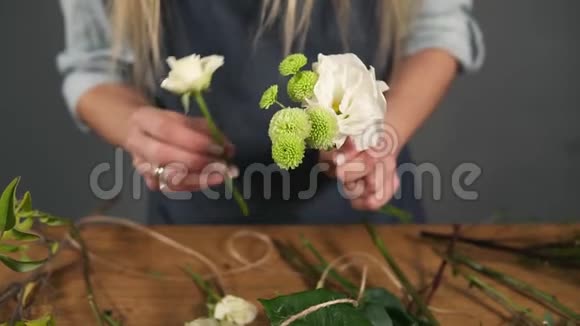 专业金发女性花艺师在花店布置精美花束的近景花卉学视频的预览图
