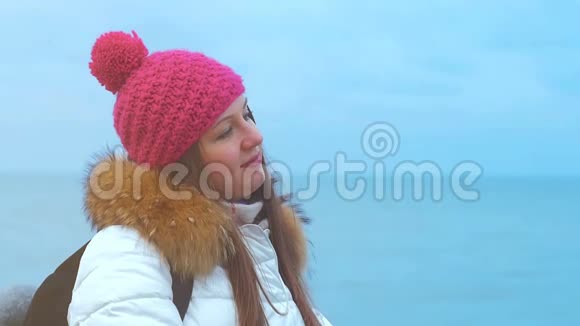 年轻女子微笑着面对冬天的大海视频的预览图