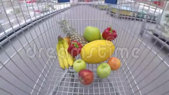 提供新鲜蔬菜和水果的购物车通过超市移动视频的预览图