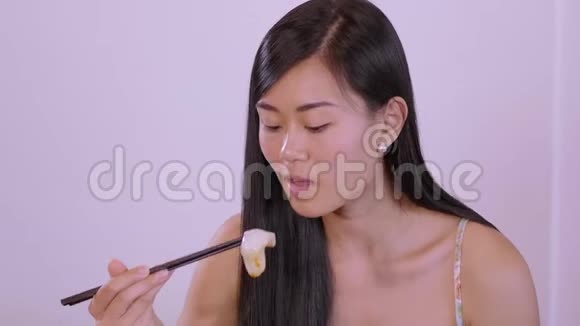 年轻漂亮的亚洲女人在餐馆吃寿司视频的预览图