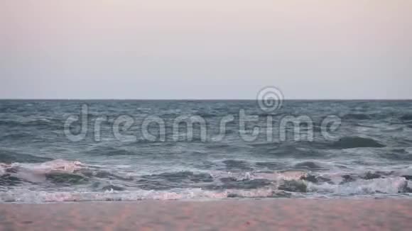海浪在沙滩上海边日落时不平静的大海上视频的预览图