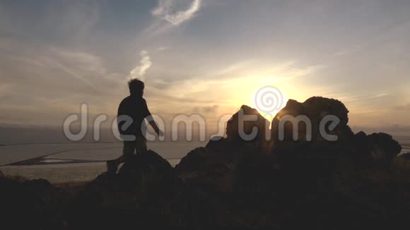 日落时分活跃的男孩在山上徒步旅行视频的预览图