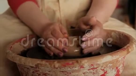 特写女性手在陶轮上塑造生黏土视频的预览图