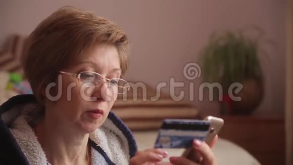 背景上有礼物的女人用智能手机上网购物用信用卡视频的预览图