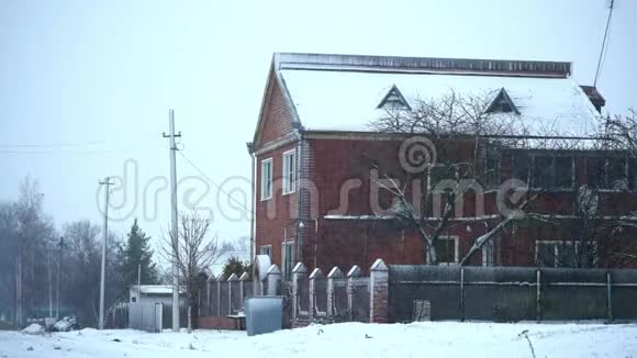 在阴天的冬天下雪的天气砖两层楼的房子视频的预览图
