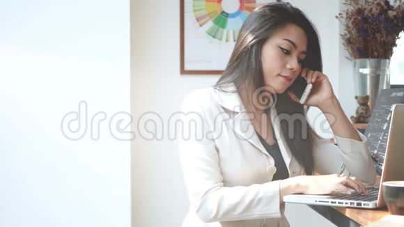 4K镜头忙碌的商务女性早上在城里的咖啡店里用笔记本电脑和智能手机工作视频的预览图