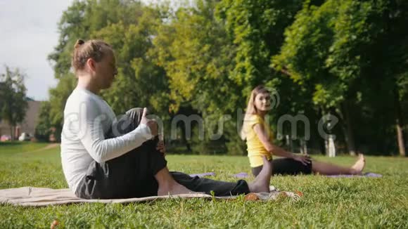 早上瑜伽教练和女孩在公园里做冥想视频的预览图