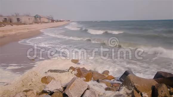 海浪在海边的岩石上破碎海浪沿着海岸翻滚暴风雨前的天气视频的预览图