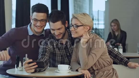 一群快乐的微笑的人在咖啡馆里一边休息一边自画像视频的预览图