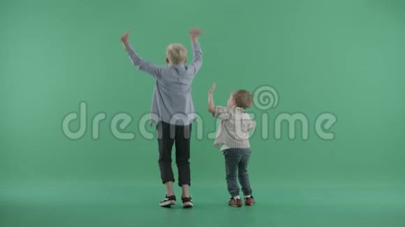 两个男孩背靠着观众挥舞着双手跳跃视频的预览图