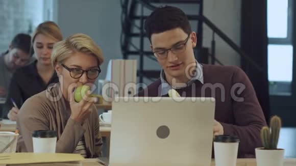 年轻的商业伙伴在办公室休息吃水果聊天视频的预览图