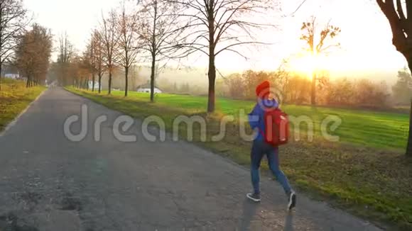 女旅行者背着背包在乡间的道路上行走欣赏周围的风景视频的预览图