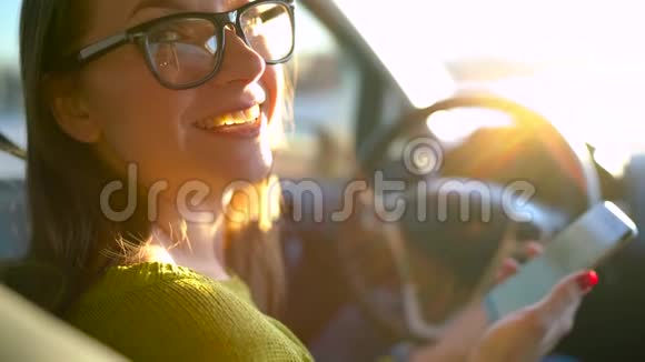 戴眼镜的女人用智能手机和车里的人说话视频的预览图