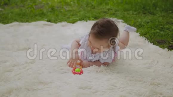 公园里一个很小很漂亮的女孩在床单上玩耍视频的预览图