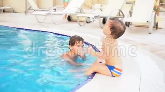 两个男孩弟弟在度假村的游泳池里洗澡视频的预览图