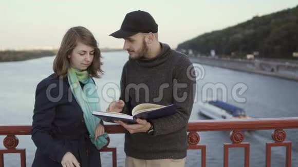 桥上的年轻人讨论这本书视频的预览图