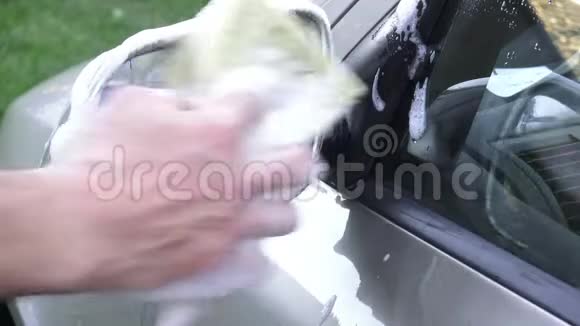 一只男性手清洗车上后视镜的照片视频的预览图