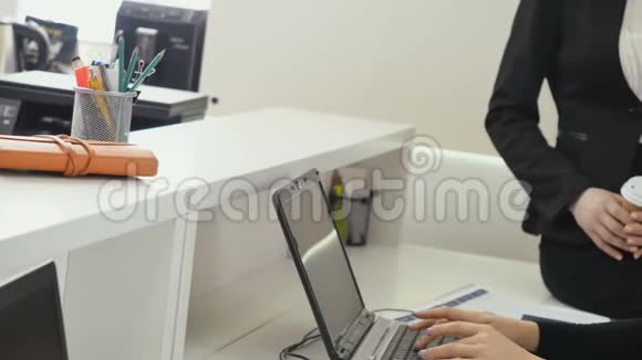 两位女商人在办公室讨论笔记本电脑上的信息视频的预览图