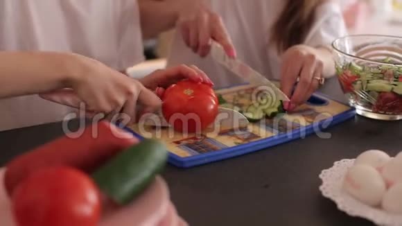 女孩在木板上切黄瓜和西红柿视频的预览图