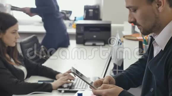 商务人士正在办公室里使用平板电脑和笔记本电脑视频的预览图