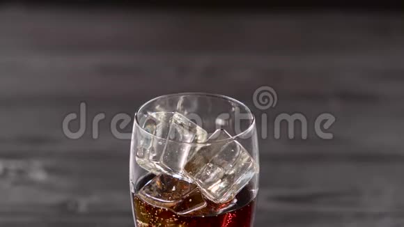 可乐和冰块一起倒进玻璃杯闭合视频的预览图