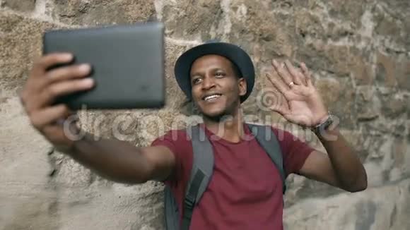 在欧洲旅行时用平板电脑在线视频聊天的快乐非洲裔美国人视频的预览图