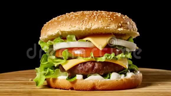 家庭制作的牛肉汉堡和生菜和蛋黄酱的特写在小木砧板上深色背景视频的预览图