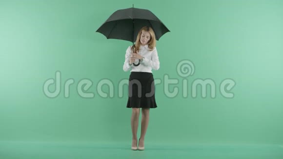 一个女商人站在雨中看着她的手表视频的预览图