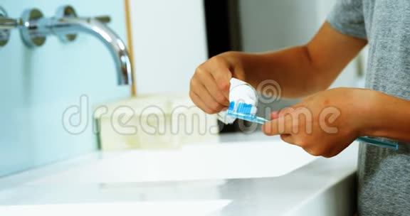 男孩子把牙贴在浴室的刷子上视频的预览图