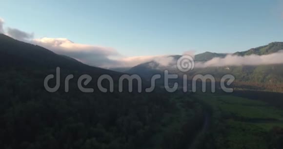 带山地景观的公路鸟瞰图晨雾笼罩着山谷中的山脉和河流4K视频的预览图