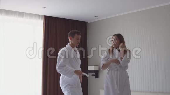 到达酒店后年轻的幸福夫妇在床上跳着舞视频的预览图